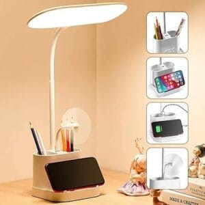 Adjustable LED desk lamp with wireless charging, phone holder, and storage tray for a modern workspace.