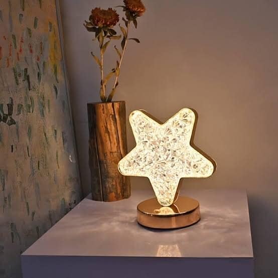 Illuminated star-shaped decorative lamp on white table at Nus Haat.