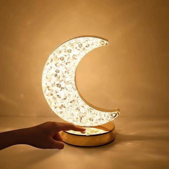 Illuminated moon-shaped table lamp with crystal details, perfect for home decor and ambient lighting.